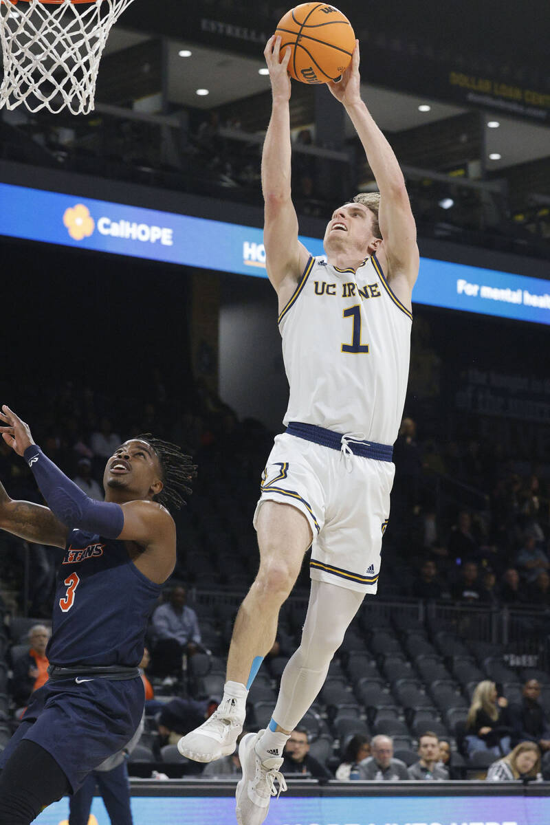 UC Irvine Anteaters guard Dawson Baker (1) attempts a jump shot as Cal State Fullerton Titans g ...