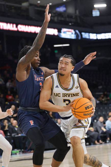 UC Irvine Anteaters guard Pierre Crockrell II (3) drives to the basket as Cal State Fullerton T ...