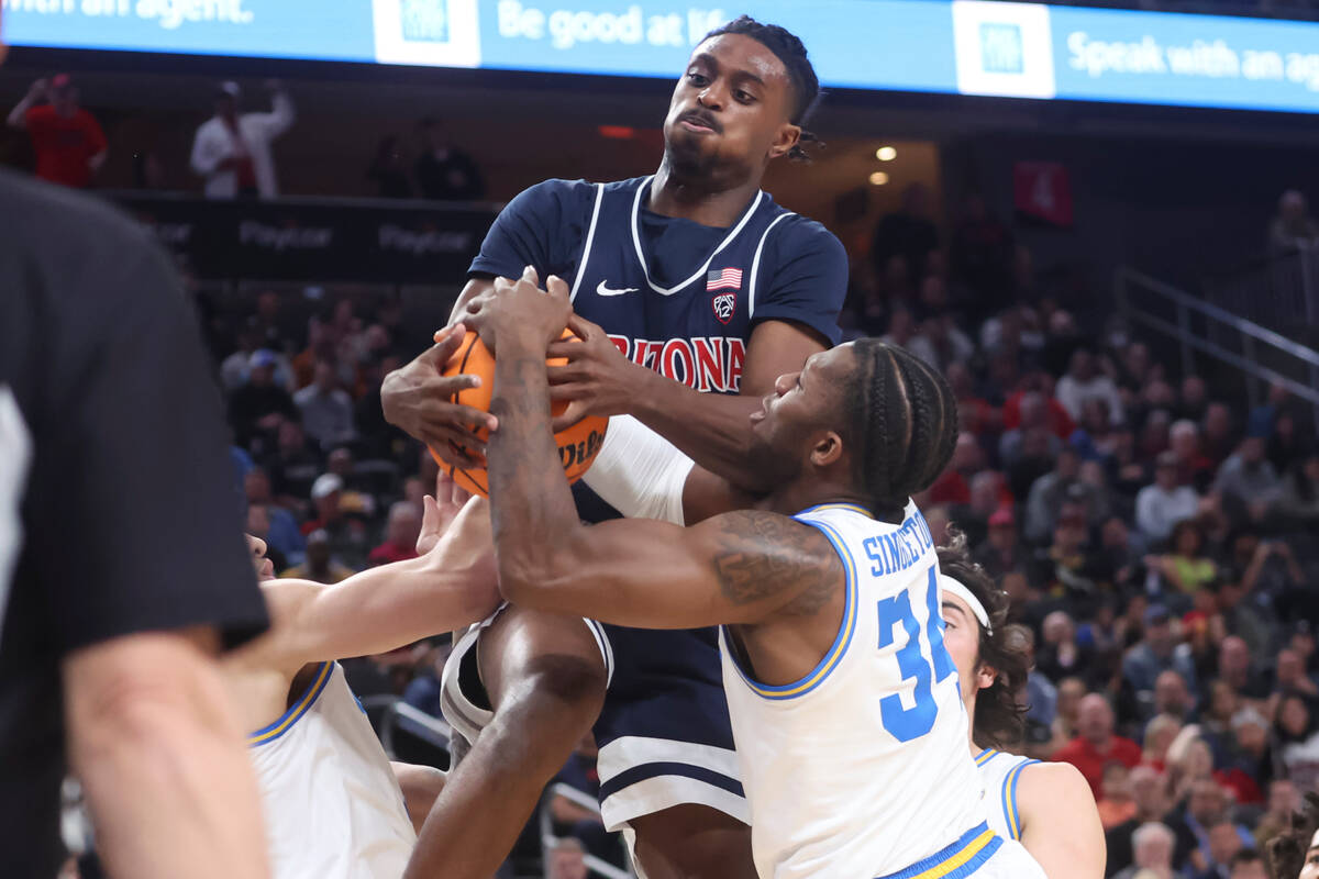 Arizona guard Cedric Henderson Jr., top, and UCLA guard David Singleton (34) vie for a rebound ...