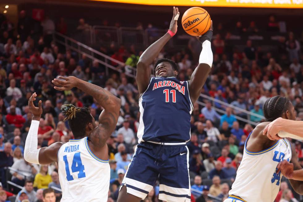 Arizona center Oumar Ballo (11) shoots against UCLA forward Kenneth Nwuba (14) during the first ...