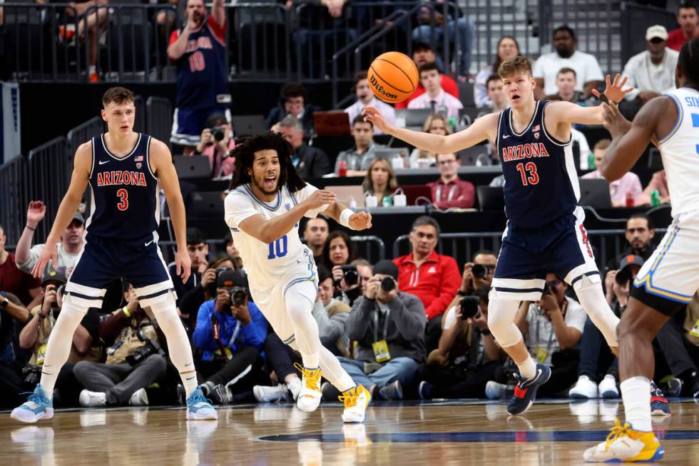 UCLA guard Tyger Campbell (10) passes the ball as Arizona guard Pelle Larsson (3) and Arizona f ...