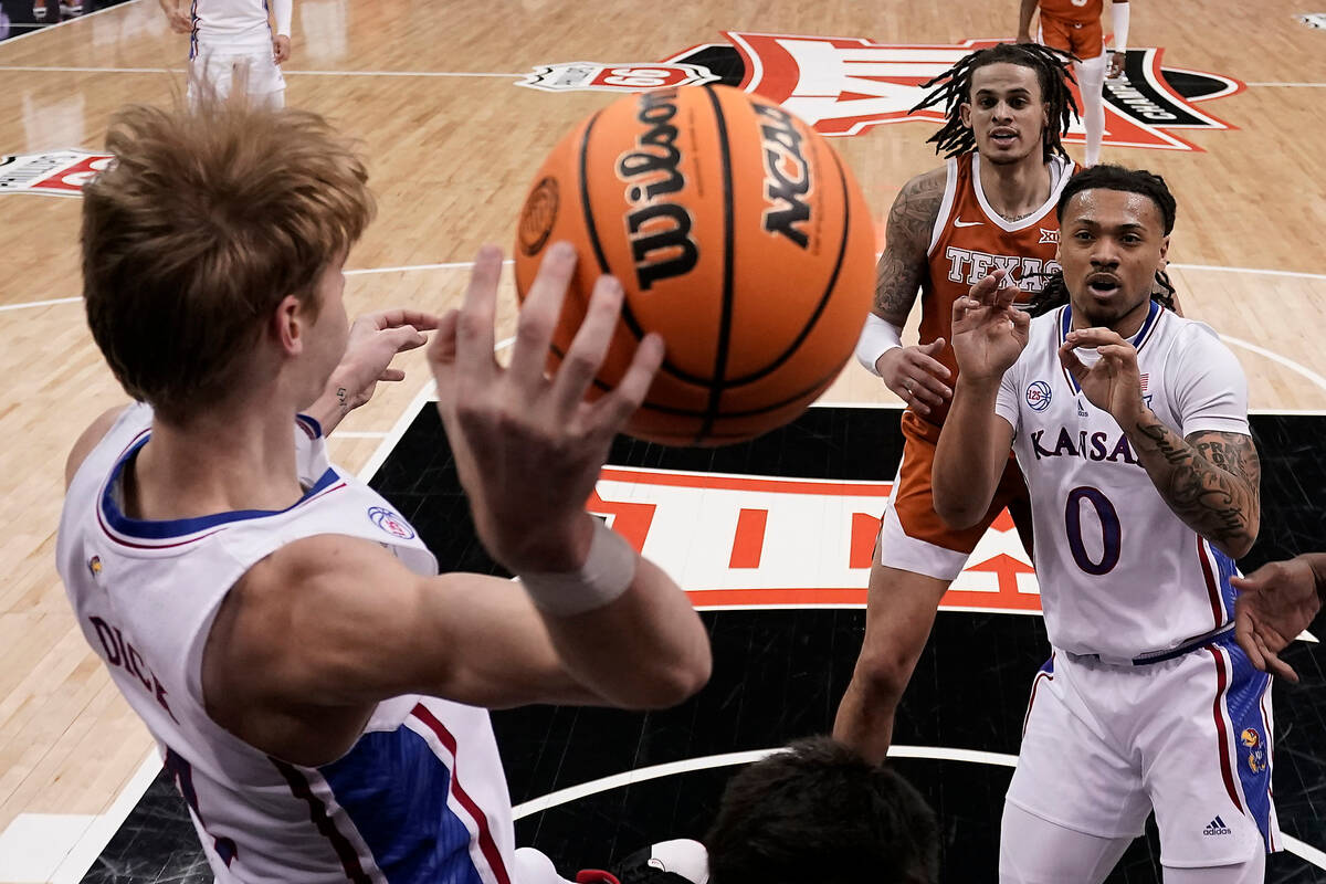 Kansas guard Gradey Dick, left, passes the ball to guard Bobby Pettiford Jr. (0) during the fir ...