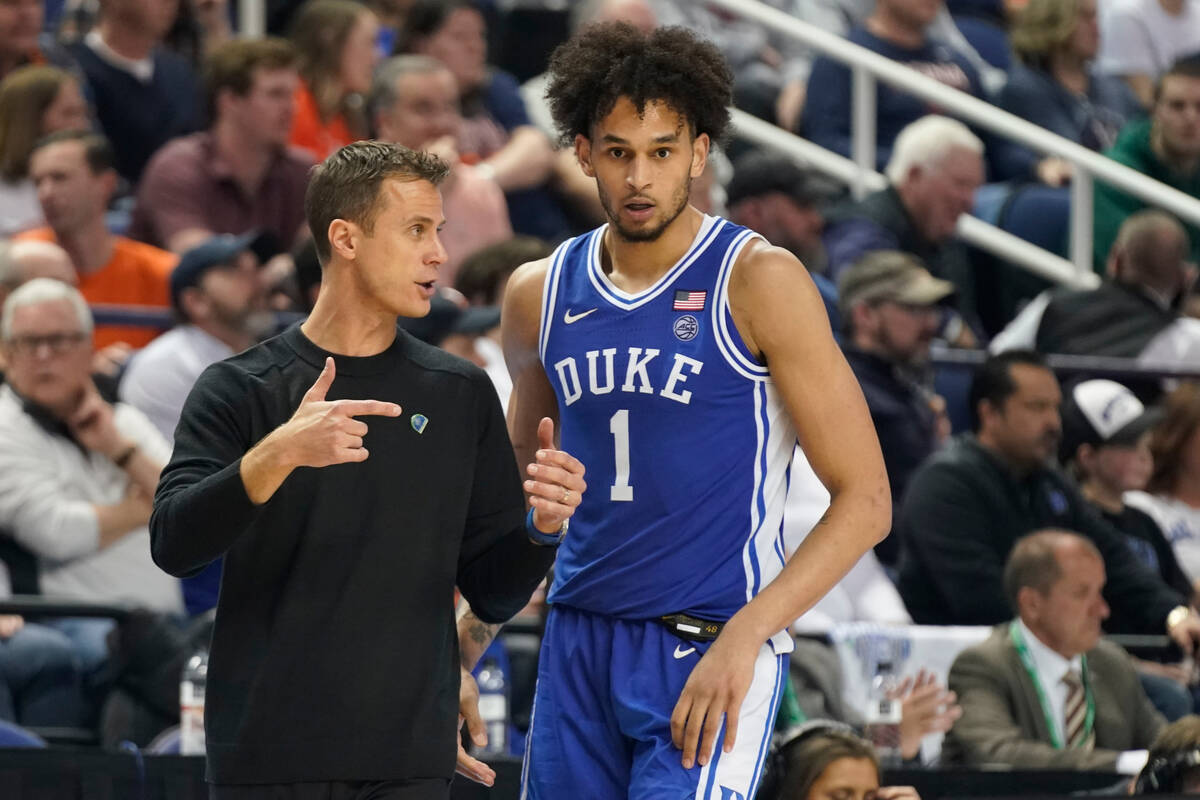 Duke head coach Jon Scheyer, left, talks with Dereck Lively II (1) during the second half of an ...