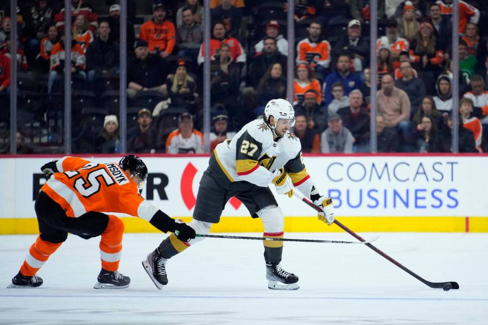 Vegas Golden Knights' Shea Theodore, right, tries to get past Philadelphia Flyers' James van Ri ...