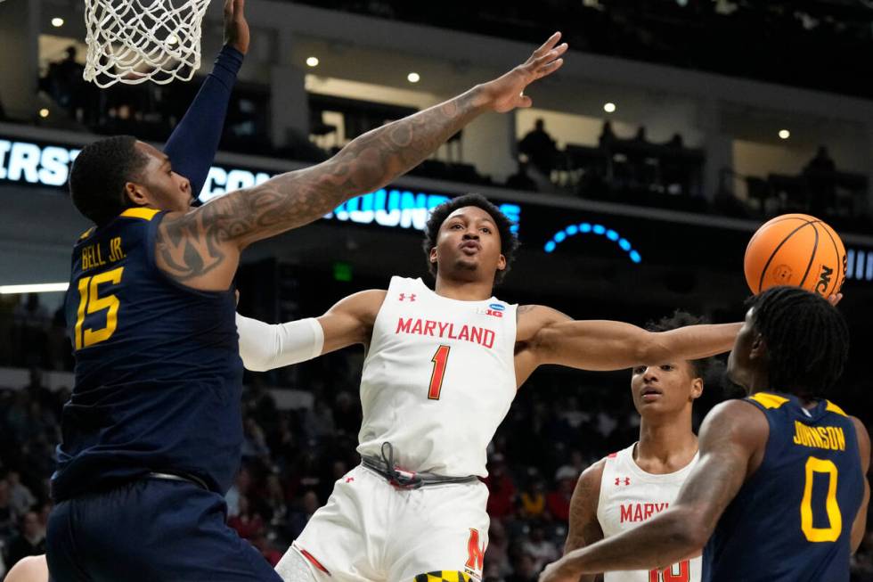 Maryland guard Jahmir Young (1) attempts a layup past West Virginia forward Jimmy Bell Jr. (15) ...