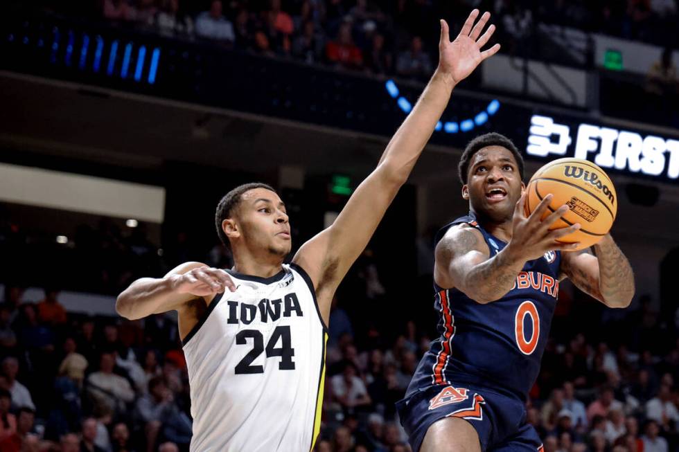 Auburn guard K.D. Johnson (0) shoots around Iowa forward Kris Murray (24) during the first half ...