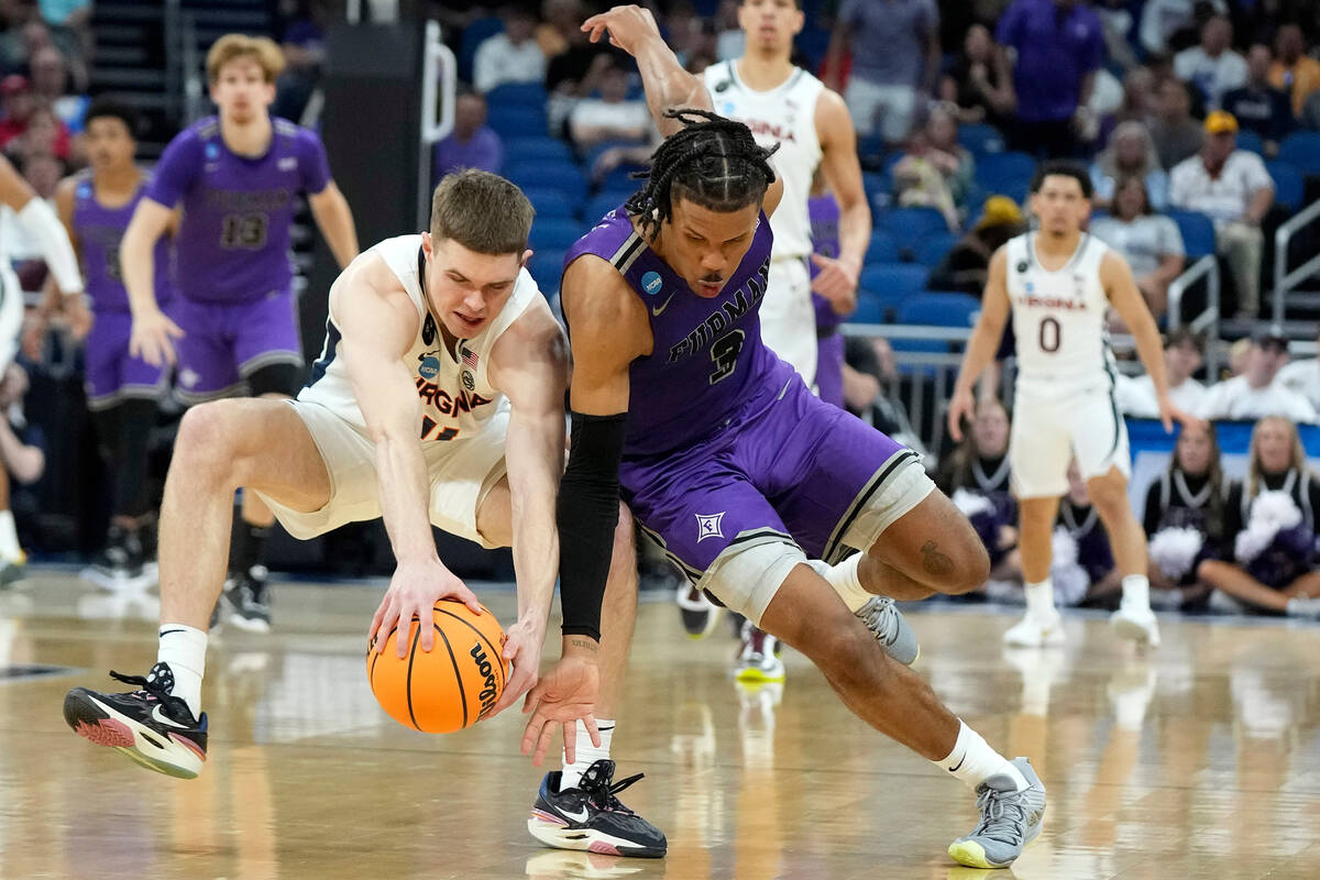 Virginia guard Isaac McKneely (11) and Furman guard Mike Bothwell (3) collide chasing a loose b ...