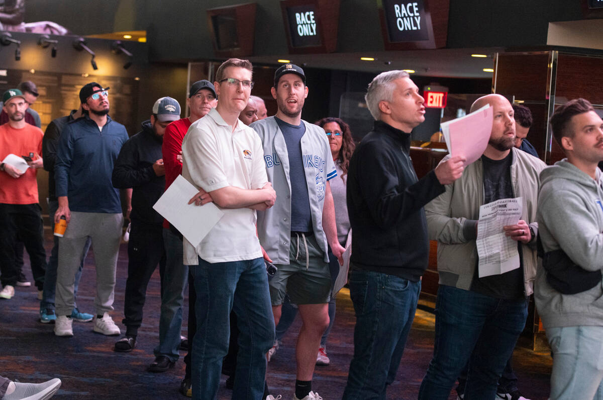 Guests line up to place bets during the first day of the NCAA basketball tournament at the West ...