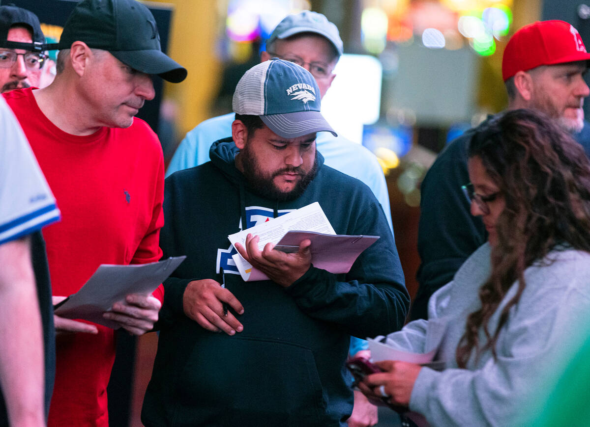 Guests, including Christian M, center, of Texas, line up to place bets during the first day of ...
