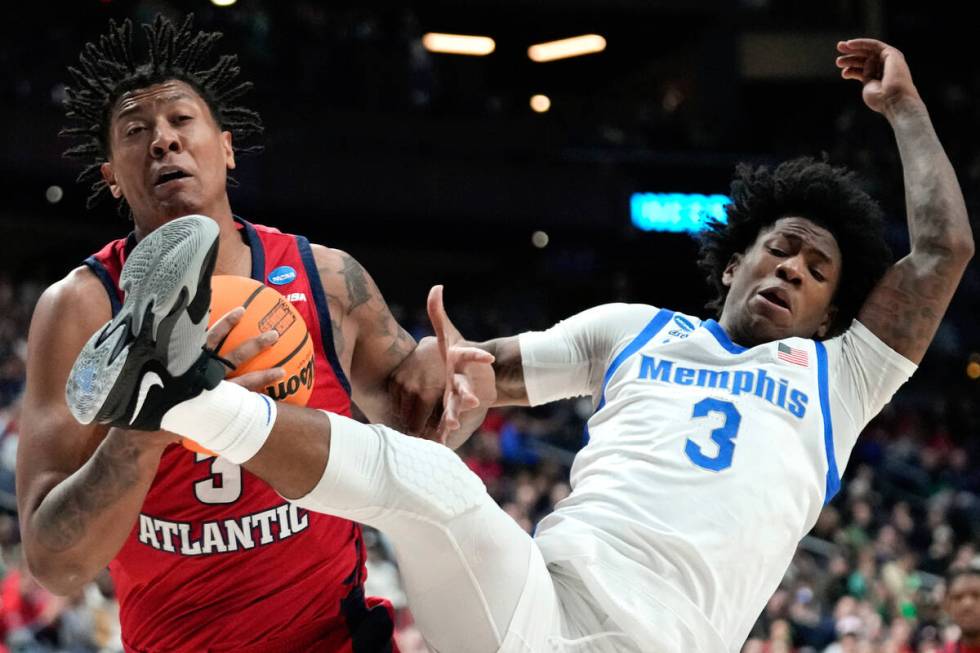 Florida Atlantic forward Giancarlo Rosado, left, pulls down a rebound from Memphis Tigers guard ...