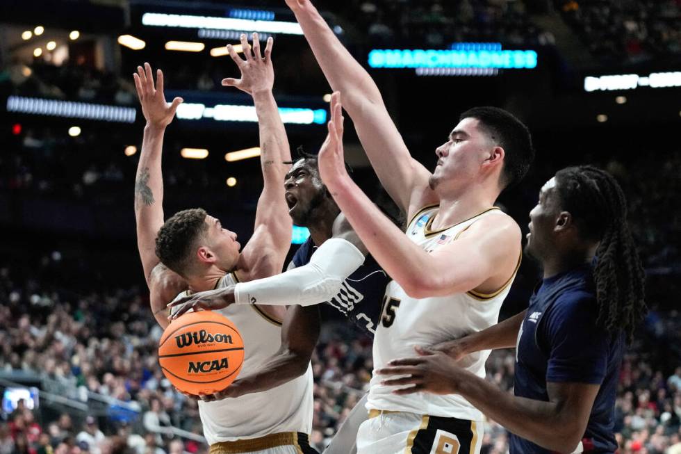 Fairleigh Dickinson guard Demetre Roberts (2) drives between Purdue forward Mason Gillis (0) an ...