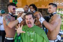 Celebrity Shaver Enoch Augustus Scott of Zombie Burlesque, center, has his head shaved by membe ...