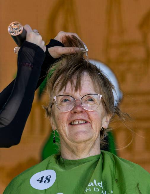 Fundraiser Karen Cyr of Kalamazoo, MI, has the first of her long hairs shaved off by stylist Ab ...