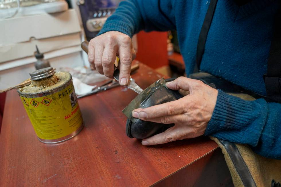 Jairo Cardenas, the owner the Alpha Shoe Repair Corp., repairs a boot, Friday, Feb. 3, 2023, in ...