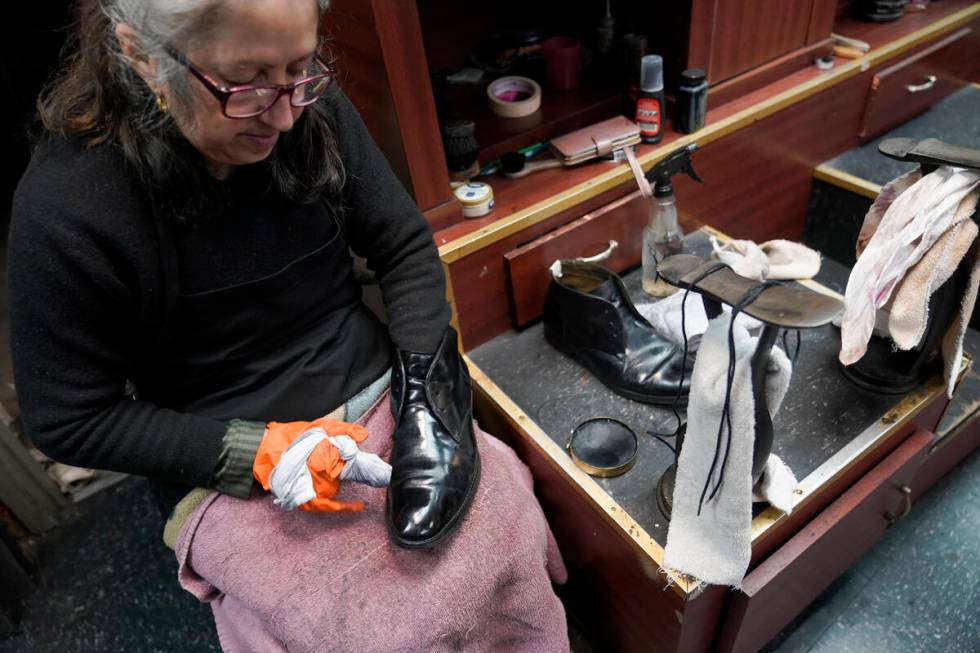 Bertha Gomez shines a customer's shoe at the Alpha Shoe Repair Corp., Friday, Feb. 3, 2023, in ...