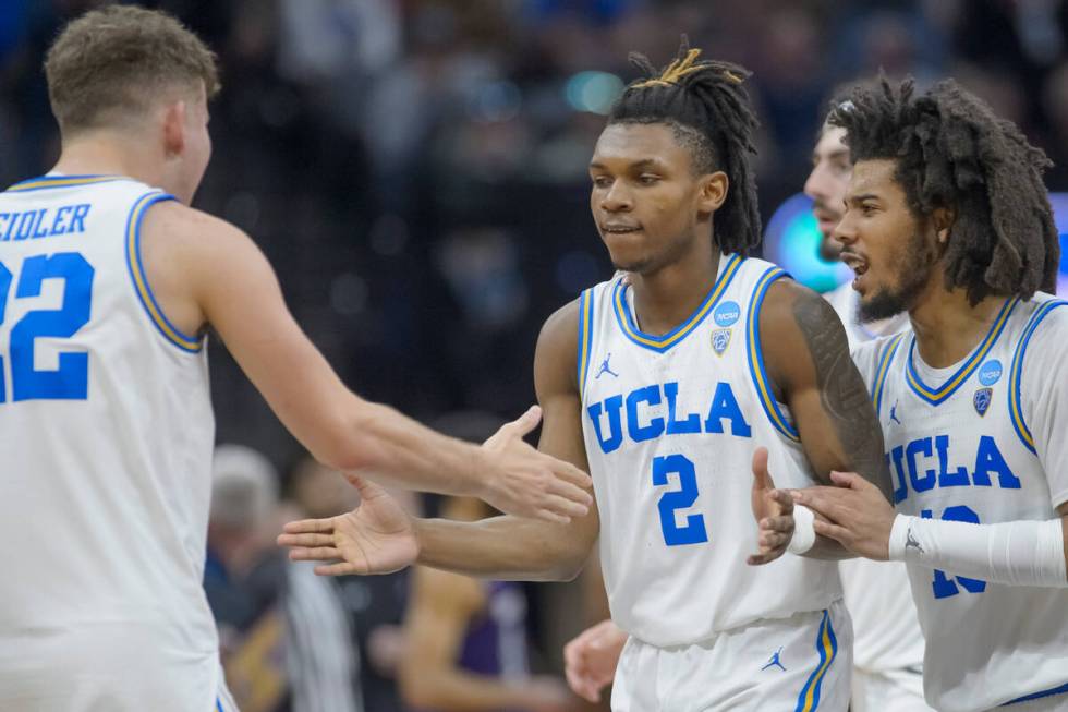 UCLA guard Jack Seidler, left, congratulates guard Dylan Andrews (2) and guard Tyger Campbell a ...