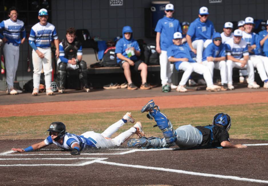 Basic's Ty Southisene (3) slides into home base past Green Valley's Bridger Knudson (8) during ...