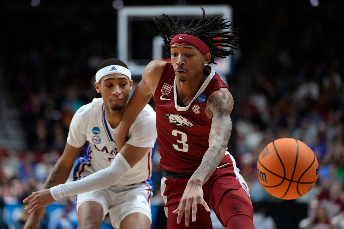 Arkansas guard Nick Smith Jr. loses control of the ball as he drives past Kansas guard Dajuan H ...