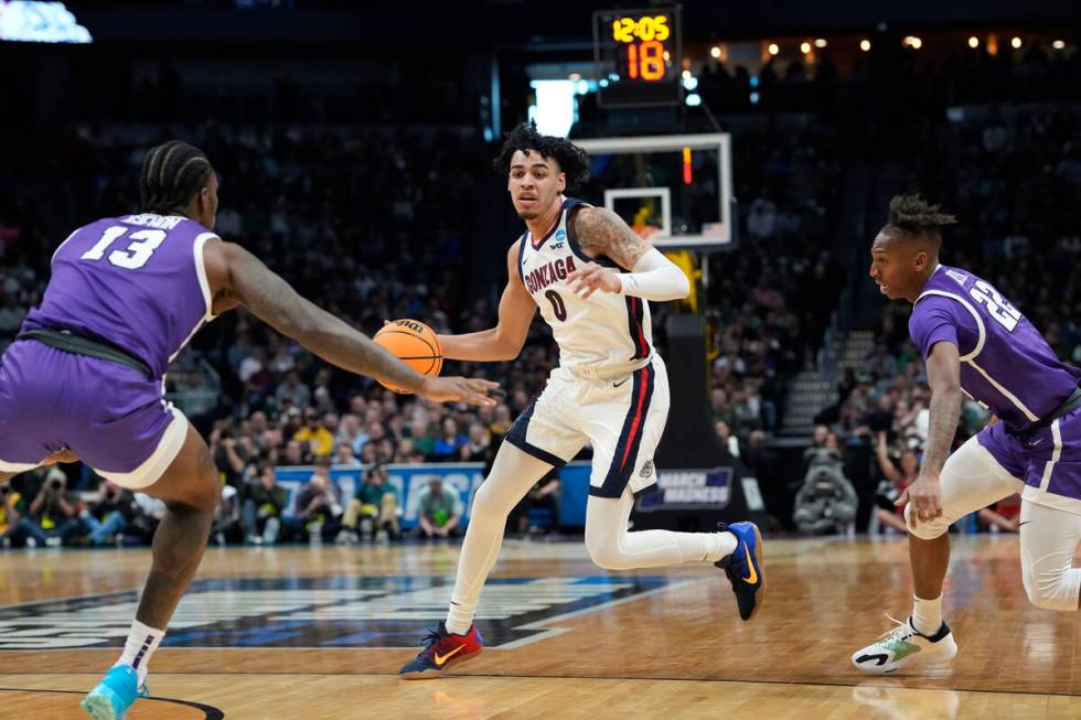 Gonzaga guard Julian Strawther, center, drives between Grand Canyon forward Aidan Igiehon, left ...