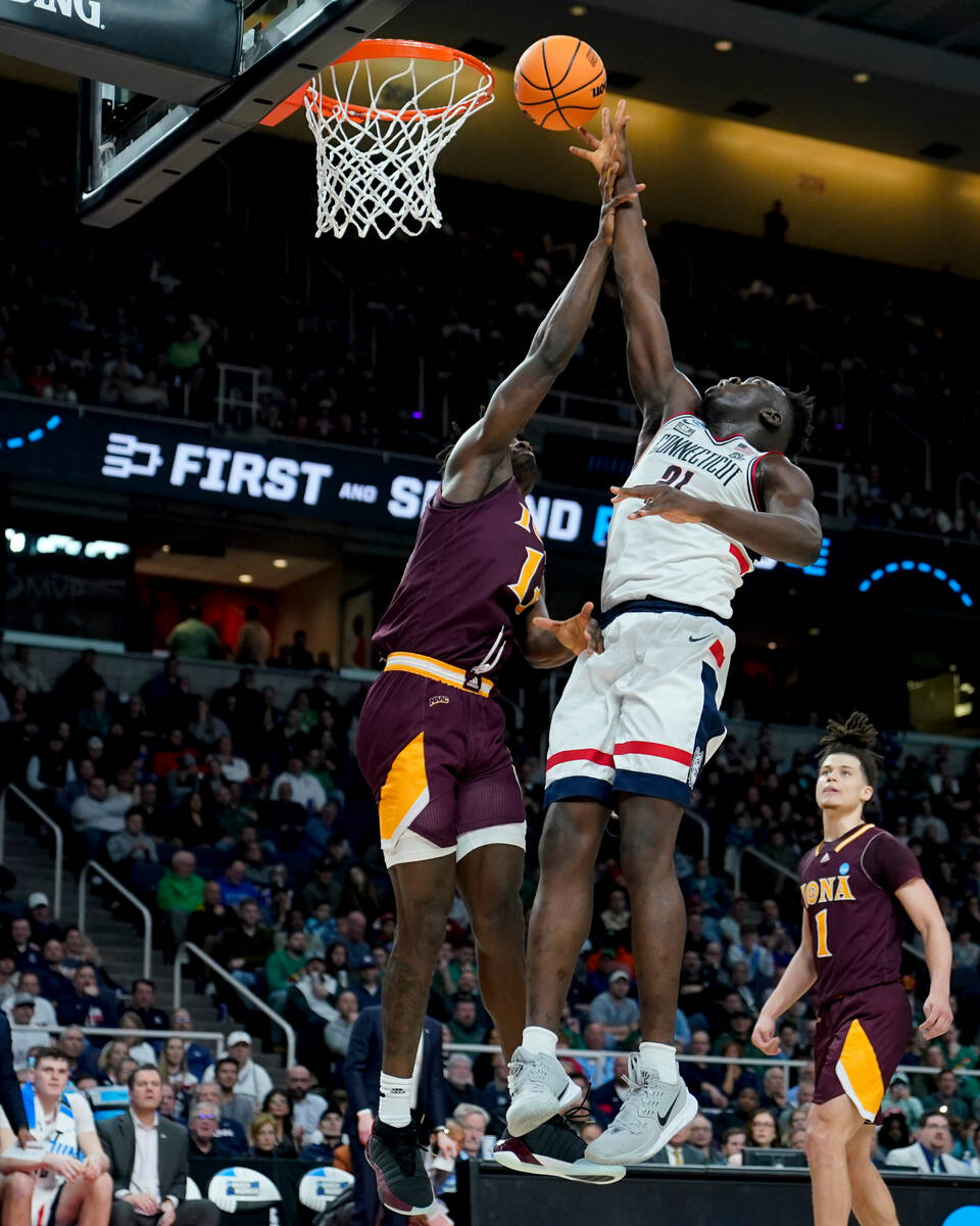 Connecticut's Adama Sanogo, right, shoots against Iona's Anton Brookshire, left, in the second ...