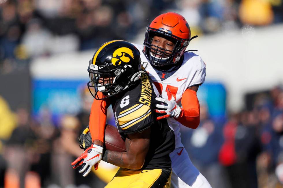 Iowa wide receiver Ihmir Smith-Marsette, left, catches a pass in front of Illinois defensive ba ...