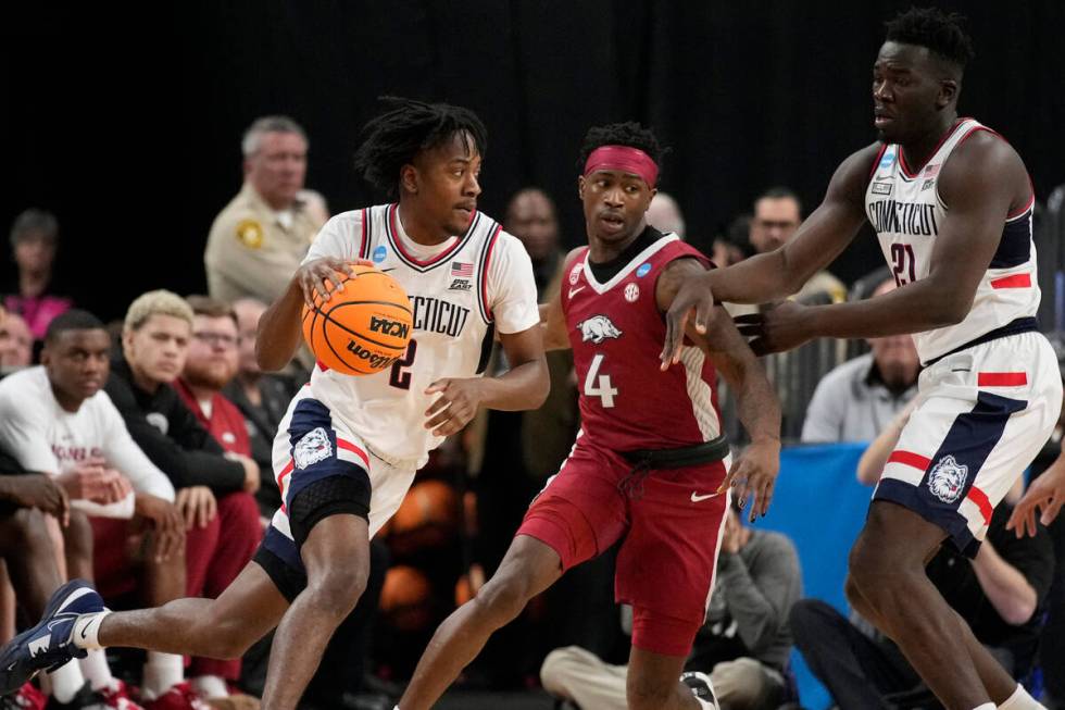 UConn guard Tristen Newton handles the ball while defended by Arkansas forward Davonte Davis in ...