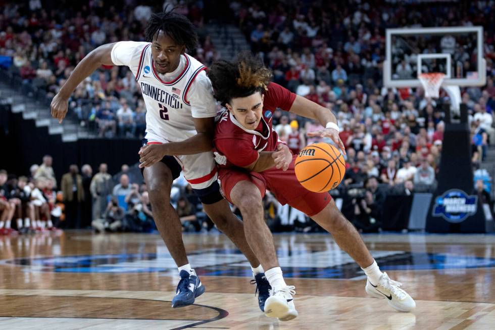 Arkansas Razorbacks guard Anthony Black (0) drives around Connecticut Huskies guard Tristen New ...