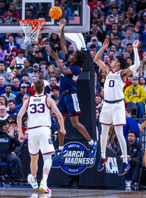 UConn guard Tristen Newton (2) gets inside of Gonzaga guard Julian Strawther (0) for another sc ...