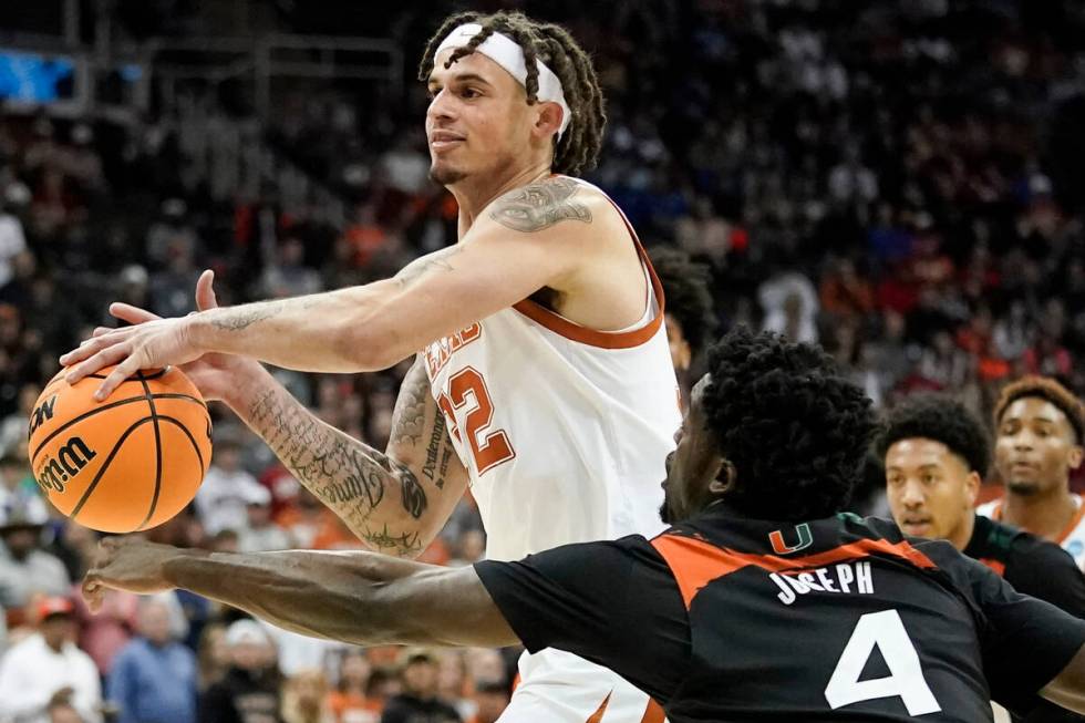 Miami guard Bensley Joseph blocks a shot by Texas forward Christian Bishop in the first half of ...