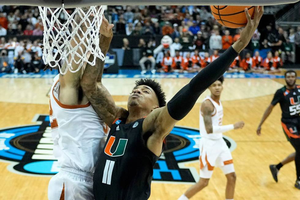 Miami forward Anthony Walker shoots over Texas forward Christian Bishop in the first half of an ...