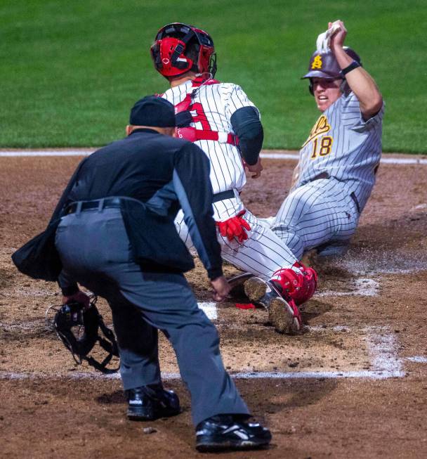 Arizona State infielder Jacob Tobias (18) slides into home against UNLV catcher Chase Gallegos ...