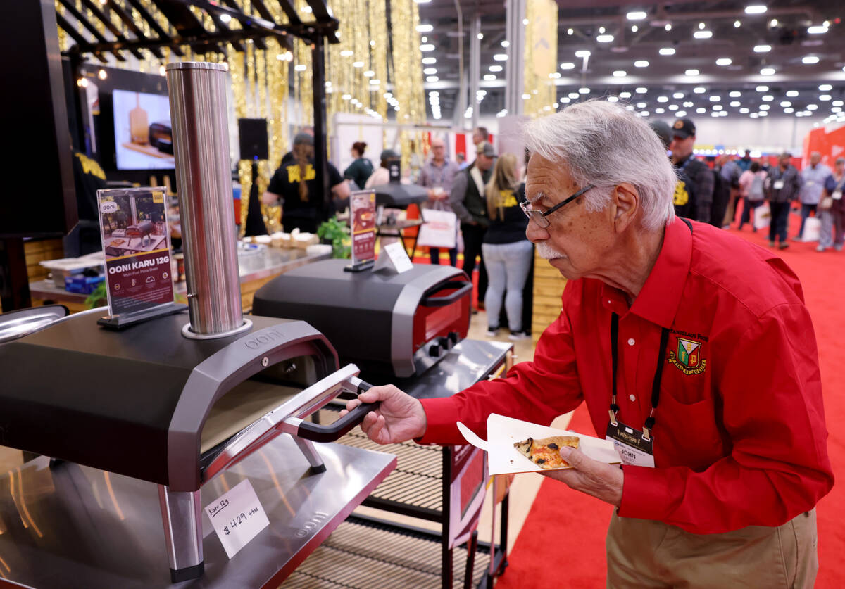 John Fablo of Las Vegas checks out pizza ovens at the Ooni booth at the International Pizza Exp ...