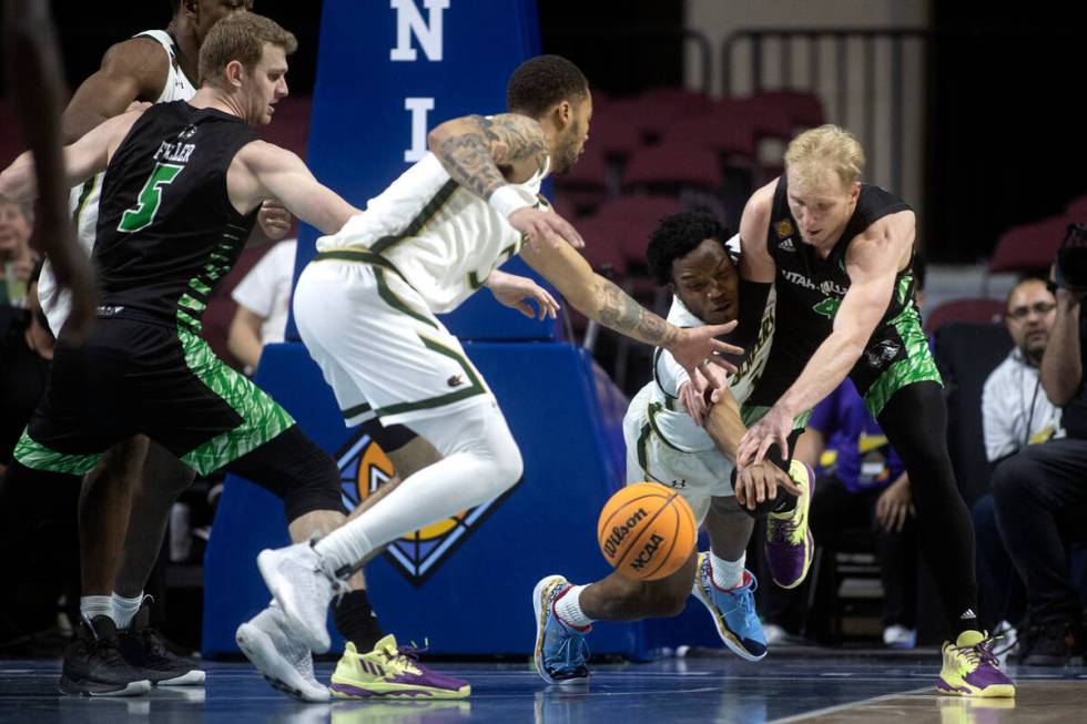 UAB Blazers guard Tavin Lovan (3) and Utah Valley Wolverines guard Trey Woodbury (4) dive for p ...