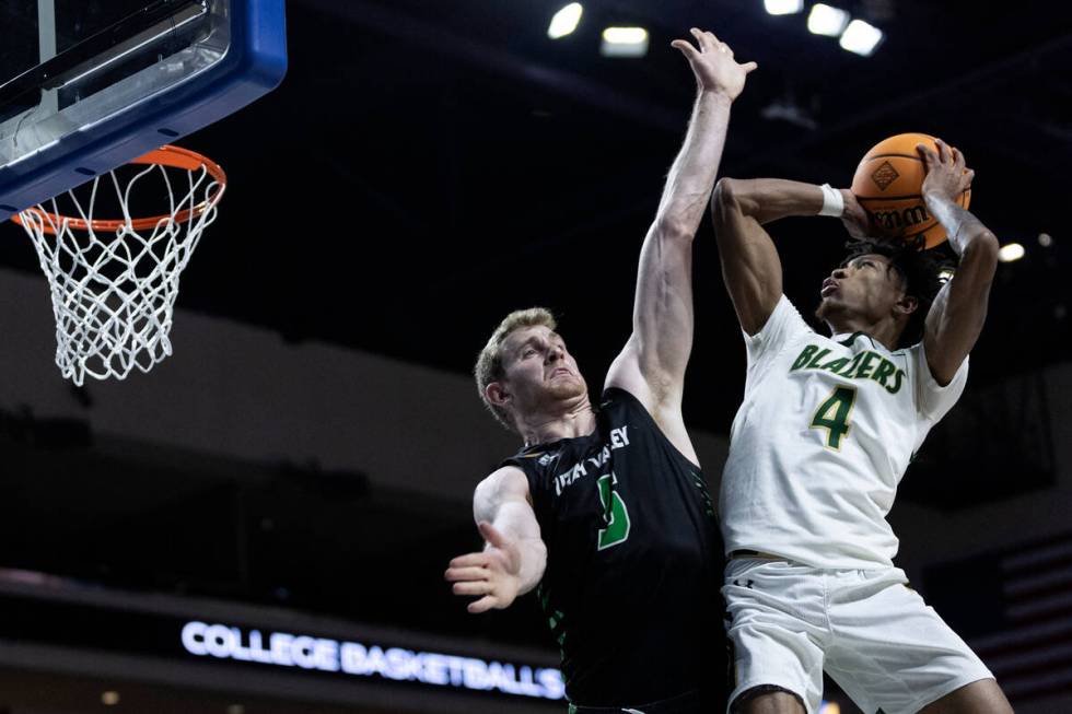 UAB Blazers guard Eric Gaines (4) shoots against Utah Valley Wolverines forward Tim Fuller (5) ...