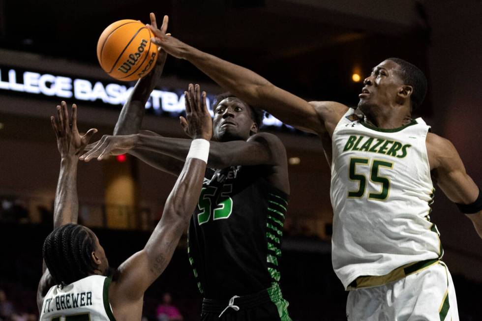 Utah Valley Wolverines center Aziz Bandaogo (55) shoots while UAB Blazers forward Ty Brewer (15 ...