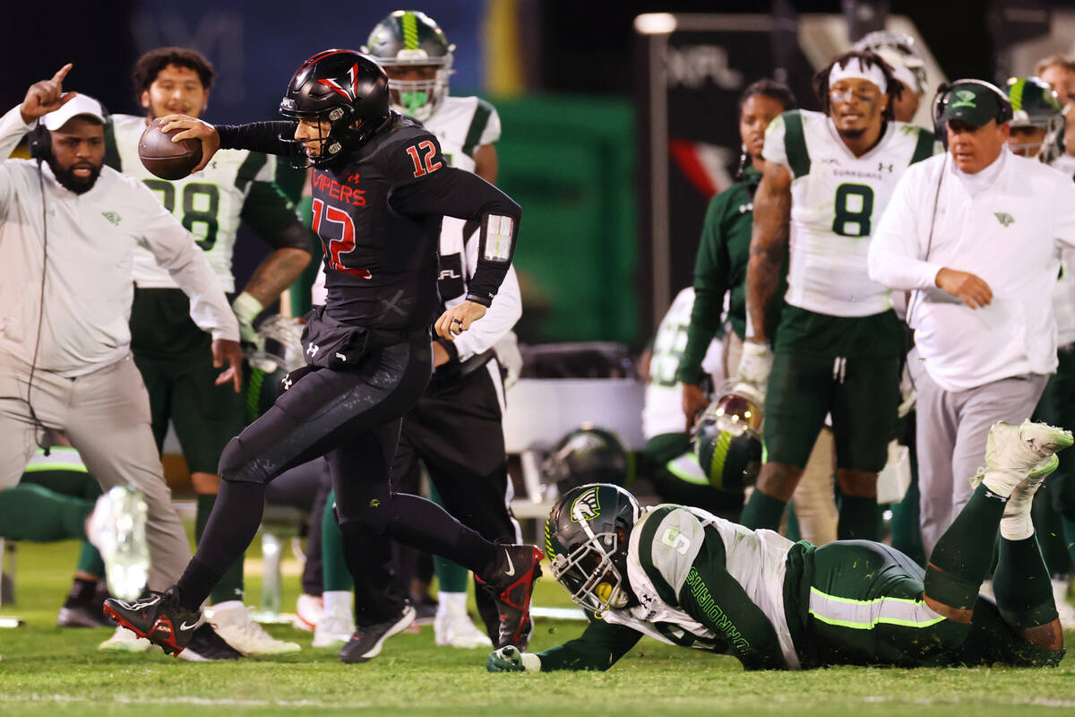 Vegas Vipers quarterback Luis Perez (12) runs the ball out of bounds while under pressure from ...