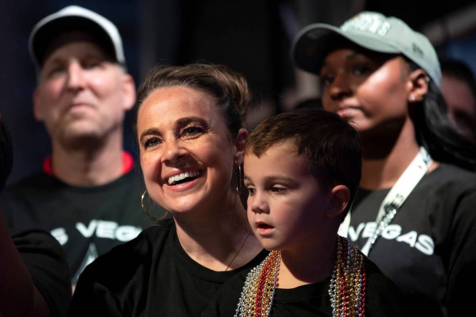 Las Vegas Aces head coach Becky Hammon, holding her son Sam Hammon, beams as A’ja Wilson ...