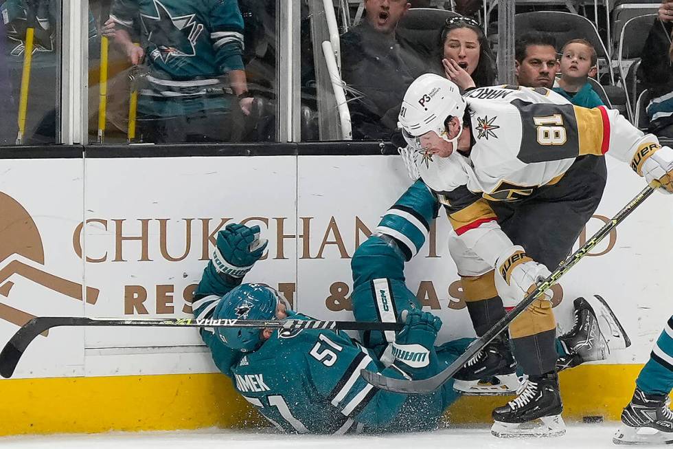 San Jose Sharks defenseman Radim Simek (51) is checked into the boards by Vegas Golden Knights ...