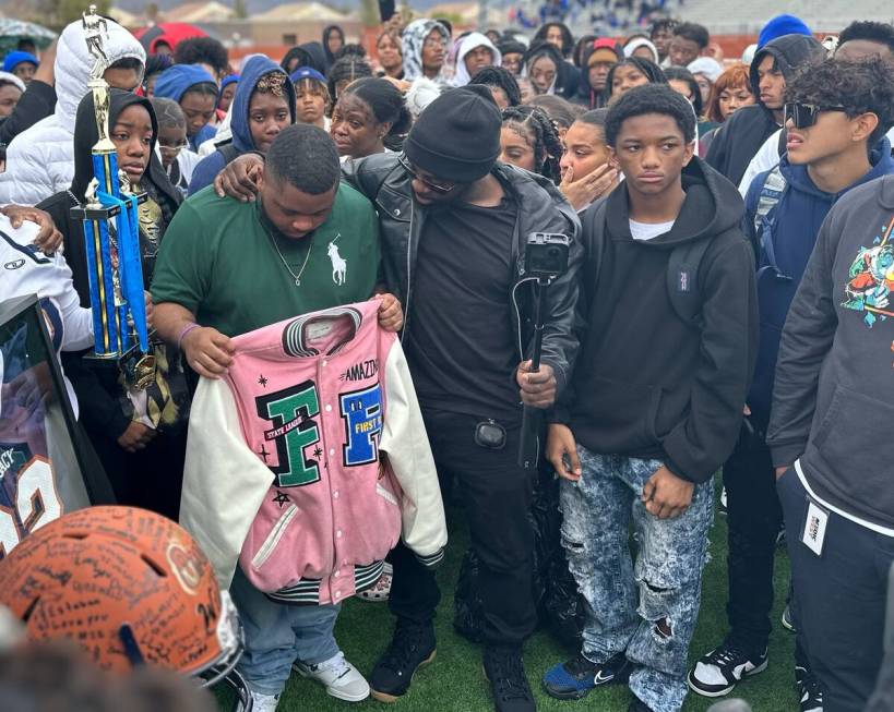 Jeremiah Wiggins, 35, center, has an arm around Quan Britton, 23, at a vigil for Omarion Wilson ...