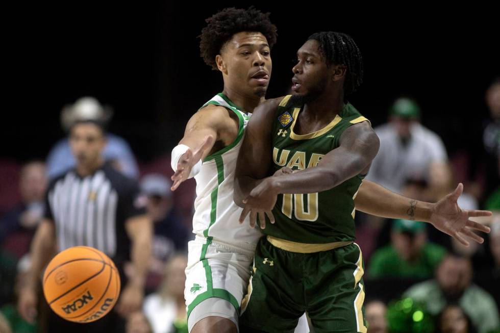 UAB Blazers guard Jordan Walker (10) passes around North Texas Mean Green guard Kai Huntsberry ...