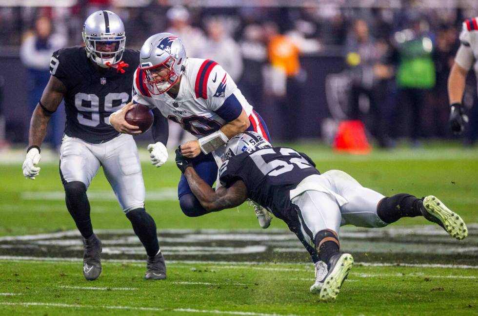 New England Patriots quarterback Mac Jones (10) is stopped by a diving Raiders linebacker Denze ...