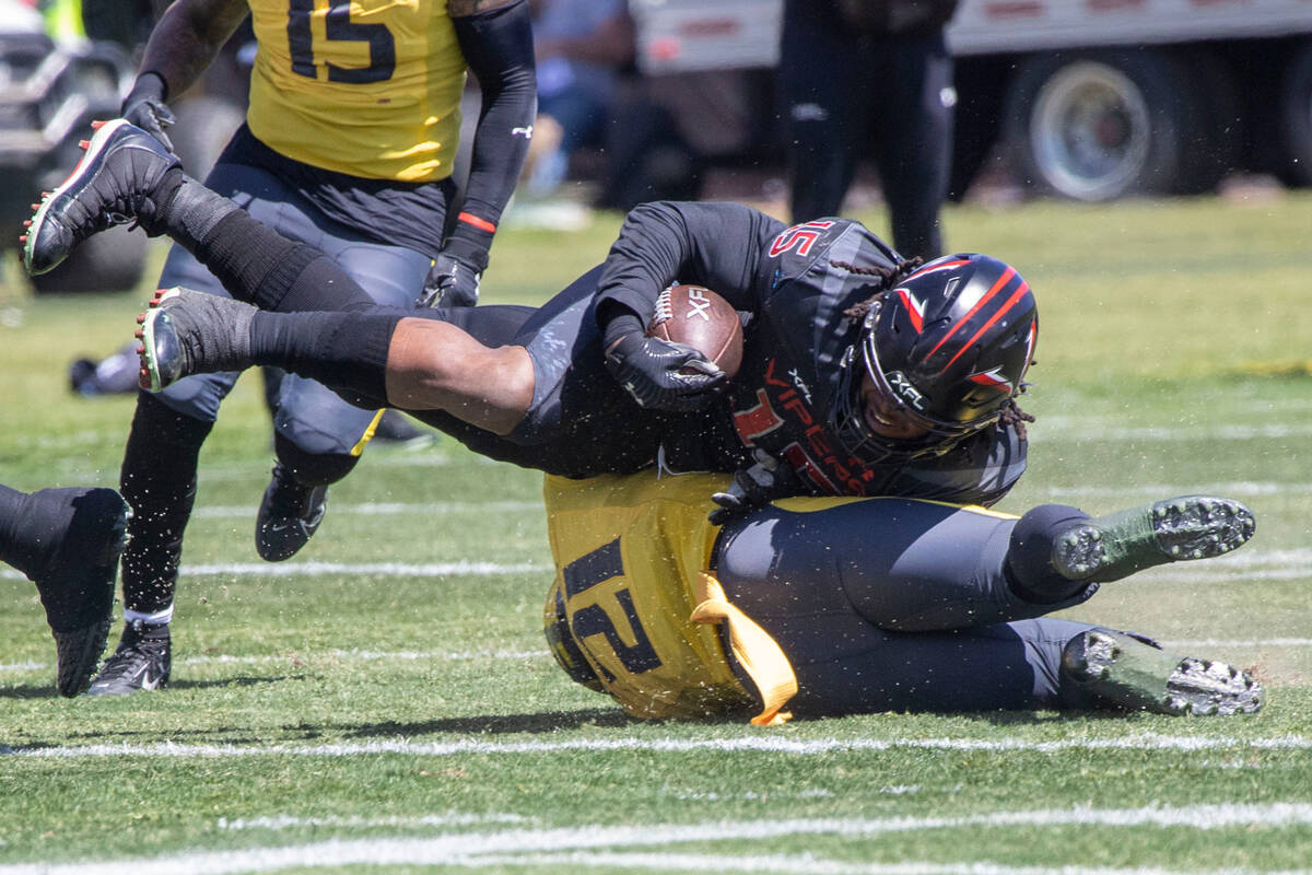 Vegas Vipers running back Rod Smith (15) tumbles over San Antonio Brahmas defensive back Sean W ...