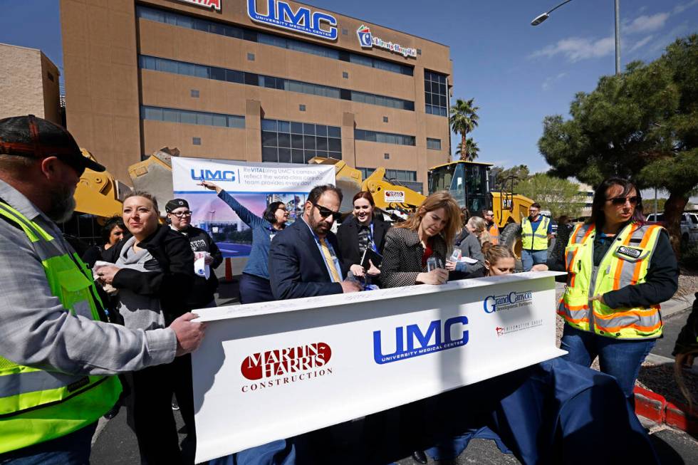 Attendees sign a beam Monday, April 3, 2023, during a groundbreaking ceremony for the ReVITALiz ...