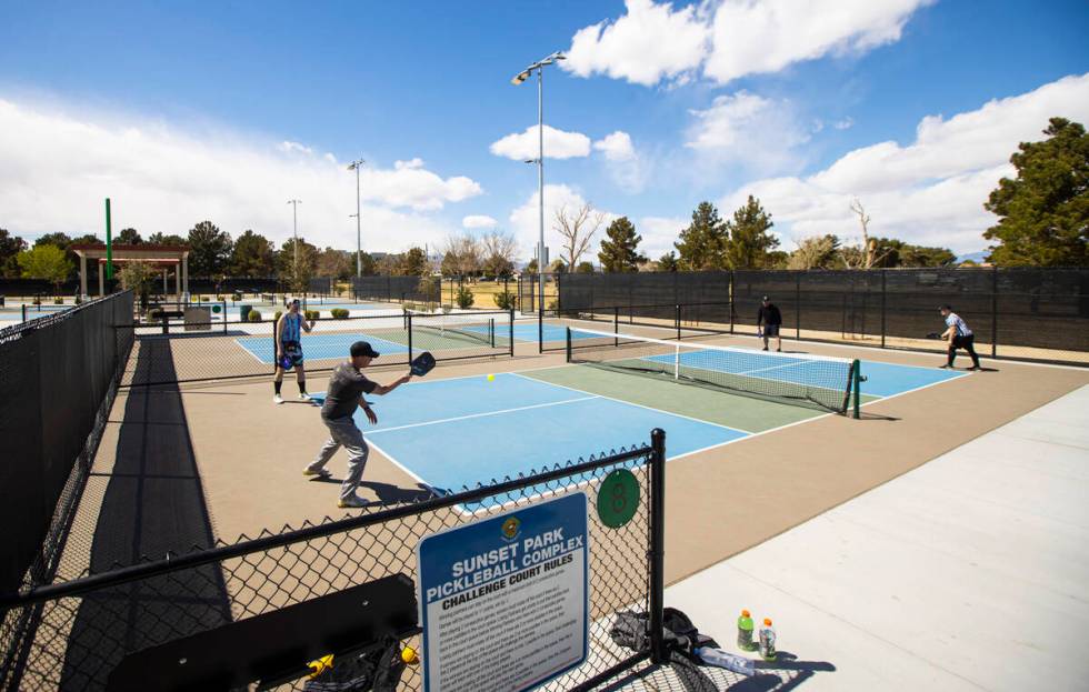 Steve Beckwith, of Henderson, second from left, swings at the ball while playing pickleball wit ...