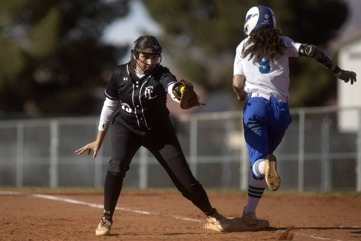Faith Lutheran’s Ava Mariani catches for an out while Green Valley’s Lyla Baxter runs throu ...