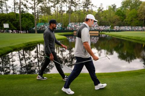Tony Finau, left, and Scottie Scheffler walk to the 15th green during a practice for the Master ...