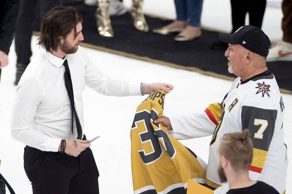 Golden Knights goaltender Logan Thompson hands a signed jersey to a fan on Fan Appreciation Nig ...