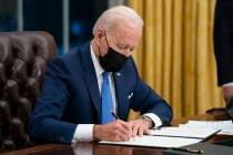 President Joe Biden signs an executive order on immigration, in the Oval Office of the White Ho ...