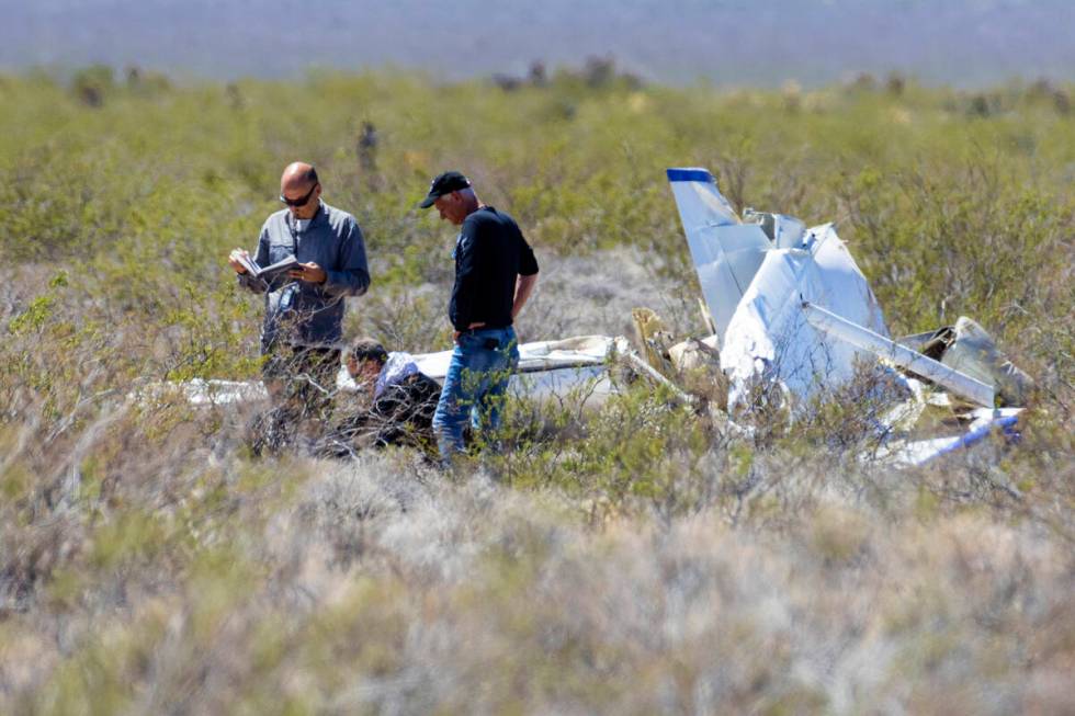 Officials from the FAA investigate a plane crash where two people died, on Tuesday, April 11, 2 ...