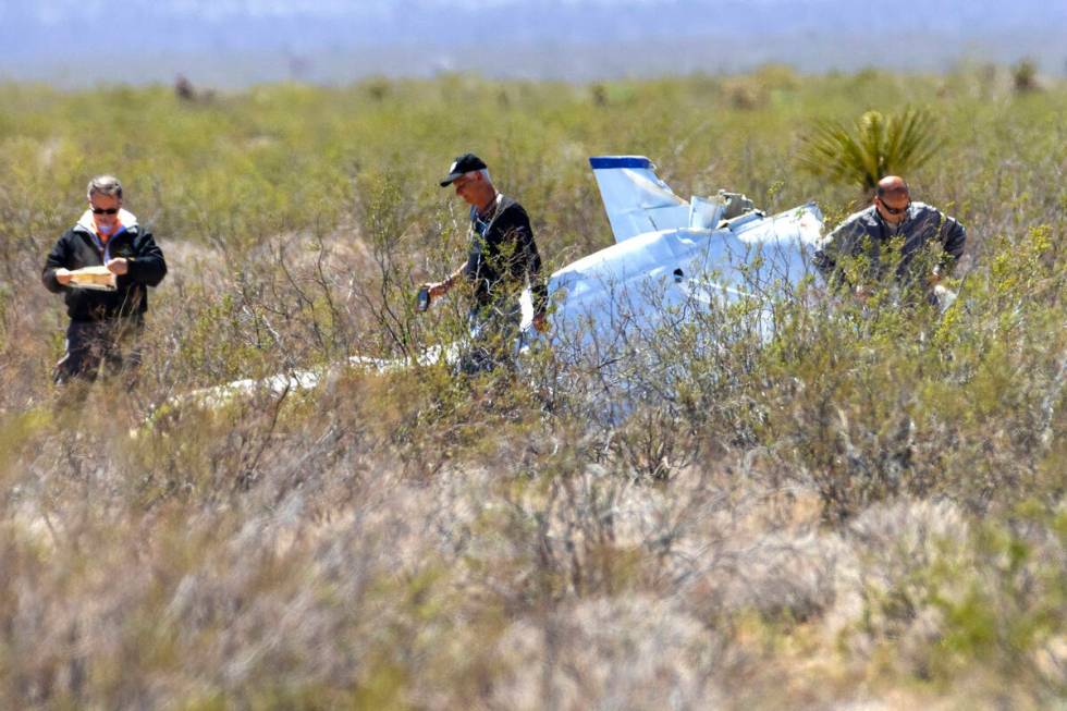 Officials from the FAA investigate a plane crash where two people died, on Tuesday, April 11, 2 ...